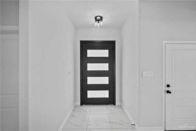 entryway featuring light marble finish floors and baseboards