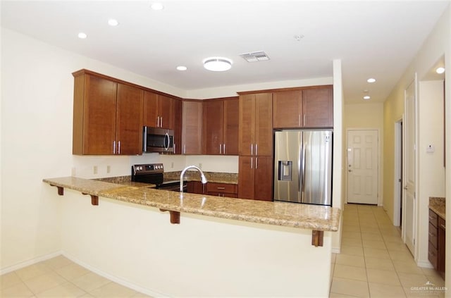 301 Houston St Unit 3303, Port Isabel, TX 78597 - kitchen featuring stainless steel appliances, a peninsula, light stone counters, a breakfast bar, and recessed lighting