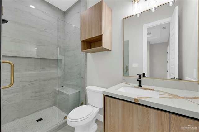 full bath with a marble finish shower, toilet, and vanity