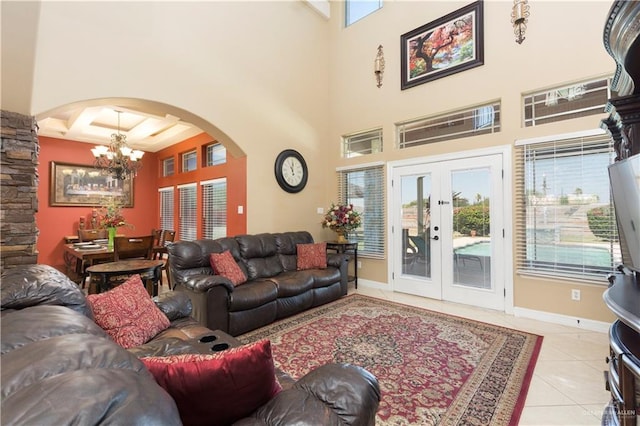 living room with french doors, a towering ceiling, light tile patterned floors, beamed ceiling, and a chandelier