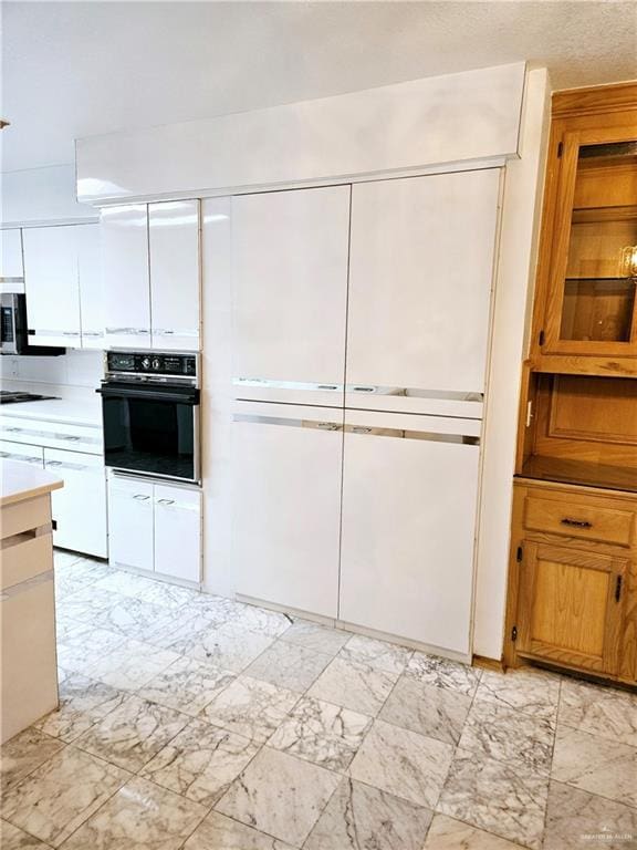 kitchen with white cabinetry and black oven