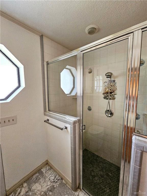 bathroom featuring a textured ceiling and walk in shower