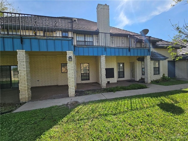 back of house featuring a patio, a balcony, and a yard