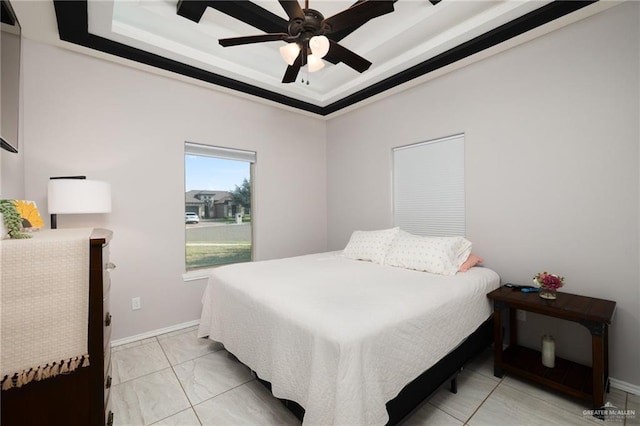 bedroom with ceiling fan and a tray ceiling