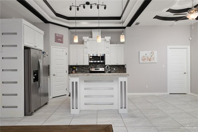 kitchen with light stone counters, hanging light fixtures, white cabinets, and appliances with stainless steel finishes