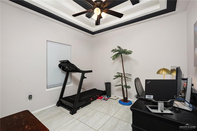 workout area with a tray ceiling and ceiling fan