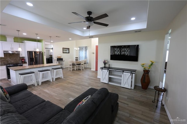 29082 Reynolds Dr, La Feria, TX 78559 - living area with a tray ceiling, ceiling fan, recessed lighting, and wood finished floors