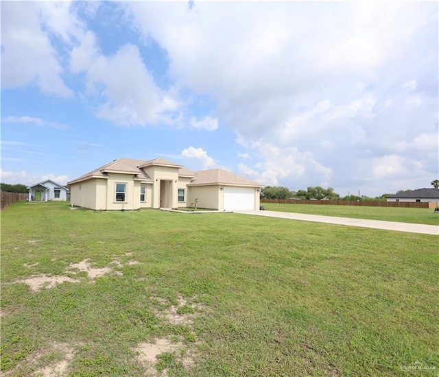 29082 Reynolds Dr, La Feria, TX 78559 - view of front of property featuring driveway, stucco siding, a front yard, and an attached garage