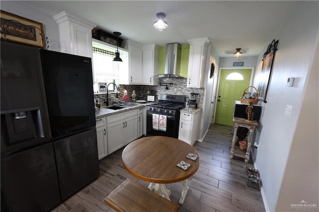 29082 Reynolds Dr, La Feria, TX 78559 - kitchen featuring fridge with ice dispenser, black gas range, wall chimney exhaust hood, backsplash, and white cabinets