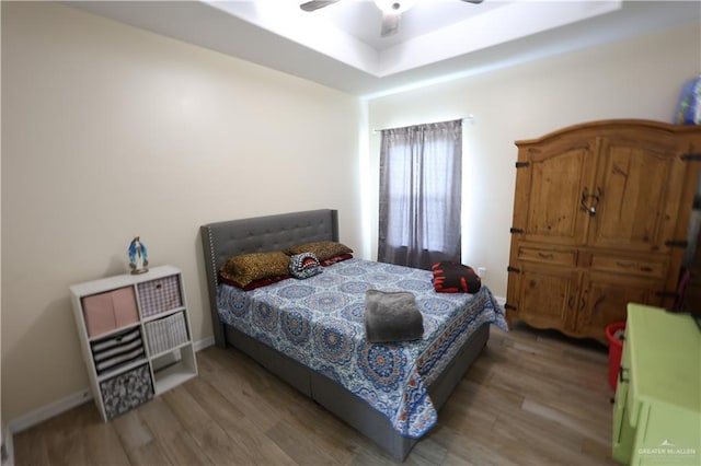 29082 Reynolds Dr, La Feria, TX 78559 - bedroom with wood finished floors, a tray ceiling, and a ceiling fan