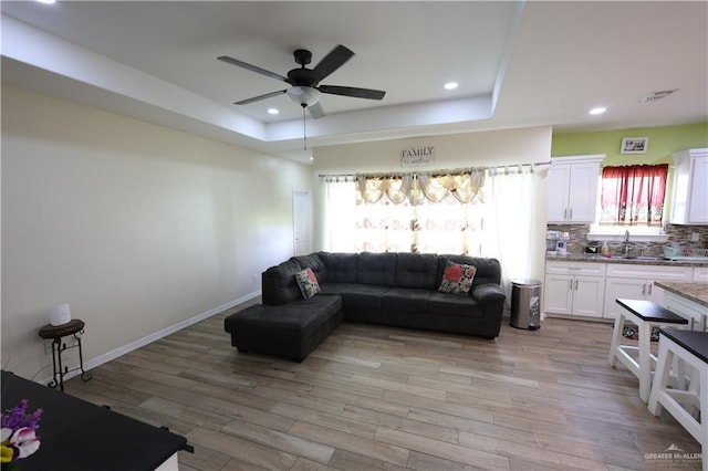 29082 Reynolds Dr, La Feria, TX 78559 - living room with a raised ceiling, a ceiling fan, light wood-type flooring, and recessed lighting
