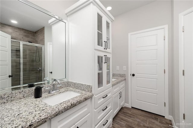 bathroom with vanity, hardwood / wood-style flooring, and walk in shower