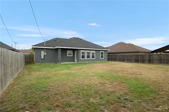 rear view of property featuring a yard