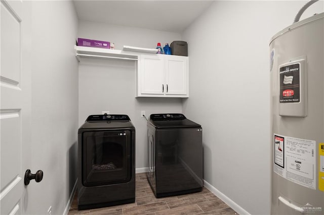 laundry room with electric water heater, washer and clothes dryer, cabinets, and dark wood-type flooring