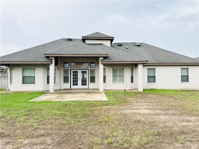 rear view of house featuring french doors, a patio, and a lawn