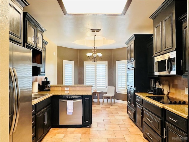 kitchen with tasteful backsplash, an inviting chandelier, decorative light fixtures, and appliances with stainless steel finishes