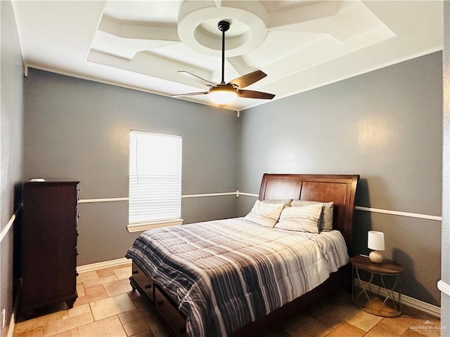 bedroom with a tray ceiling and ceiling fan