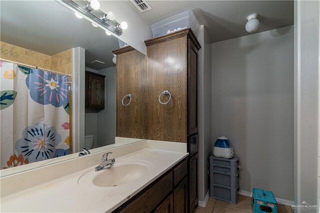 bathroom featuring tile patterned floors, vanity, and toilet