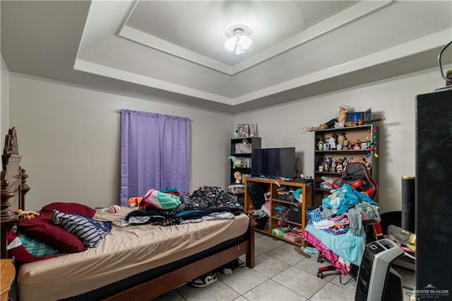 bedroom with light tile patterned floors and a raised ceiling