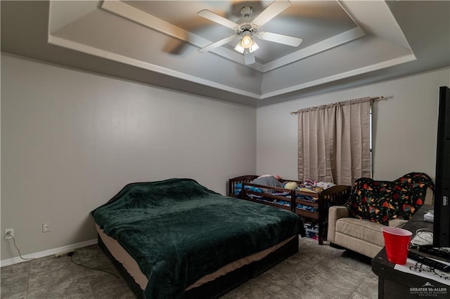 bedroom with a raised ceiling and ceiling fan