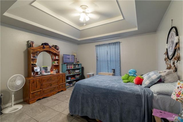 tiled bedroom with ceiling fan and a raised ceiling