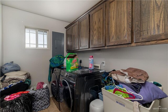 laundry room with electric panel, light tile patterned flooring, cabinets, and washing machine and dryer