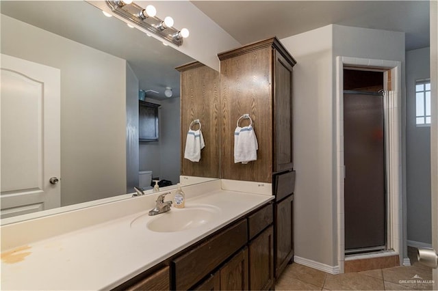 bathroom featuring tile patterned floors, vanity, toilet, and an enclosed shower