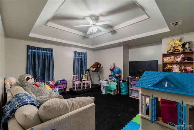 living room featuring a tray ceiling and ceiling fan