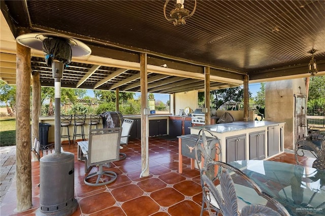 view of patio featuring an outdoor kitchen, exterior bar, and grilling area