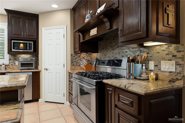 kitchen featuring light stone counters, dark brown cabinetry, stainless steel appliances, and tasteful backsplash