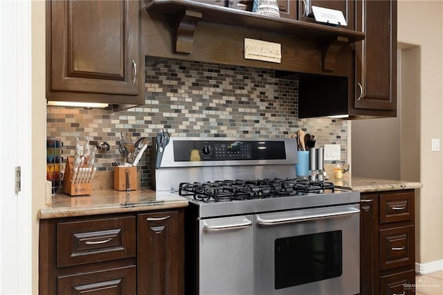 kitchen with dark brown cabinetry, stainless steel range with gas cooktop, and decorative backsplash