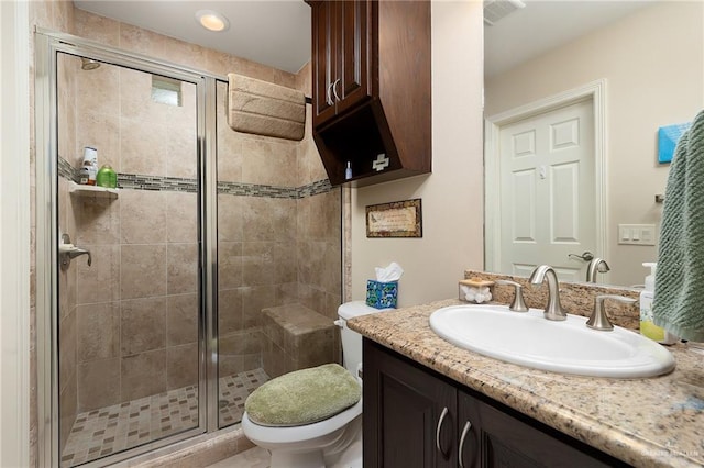 bathroom with walk in shower, vanity, and toilet