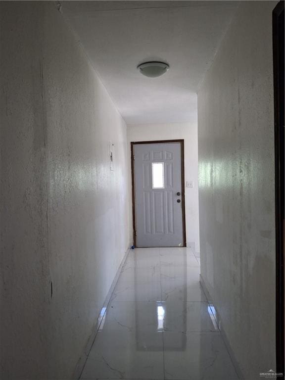 hallway featuring marble finish floor and baseboards
