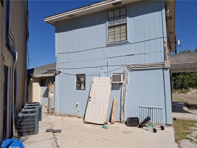 rear view of house with stucco siding and central air condition unit