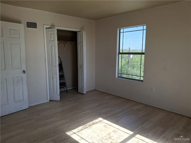 unfurnished bedroom featuring a closet, visible vents, light wood-type flooring, and baseboards