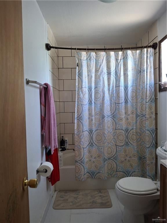 full bath with shower / tub combo, toilet, and tile patterned floors