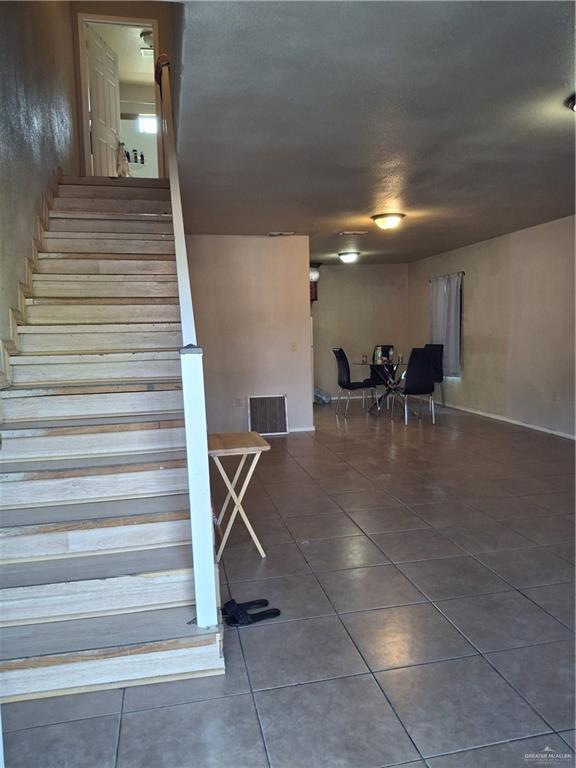 stairway with tile patterned floors and visible vents