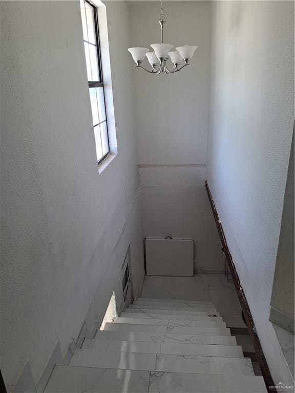 stairs featuring a notable chandelier, marble finish floor, and visible vents