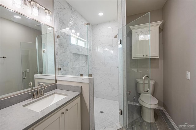 bathroom with toilet, a stall shower, baseboards, and vanity