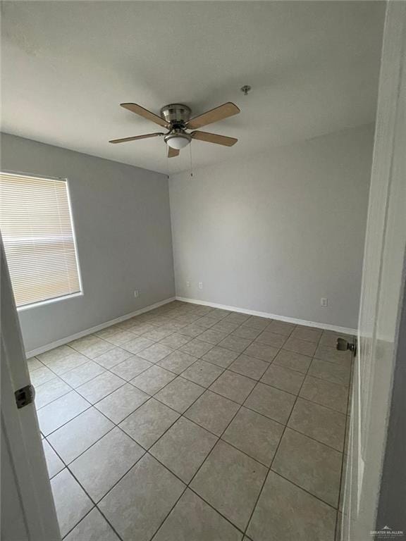 tiled spare room with ceiling fan