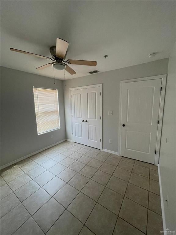 unfurnished bedroom featuring ceiling fan and light tile patterned flooring