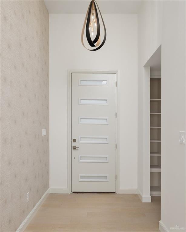 foyer featuring baseboards and light wood-style flooring
