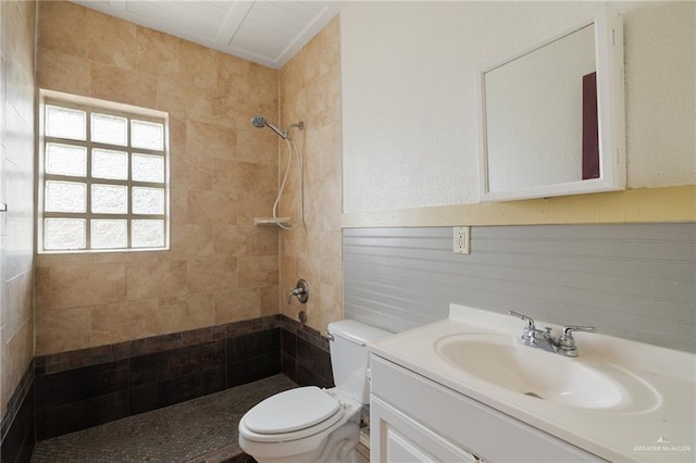 bathroom featuring vanity, toilet, and tiled shower