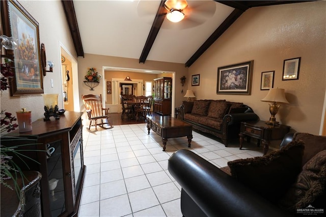 living room featuring vaulted ceiling with beams, light tile patterned flooring, and ceiling fan