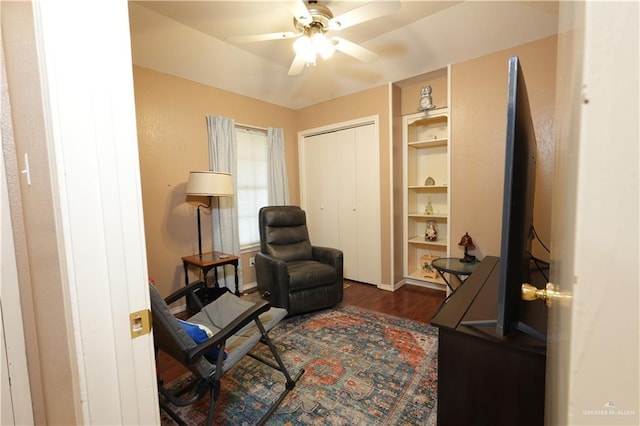 living area with ceiling fan and dark hardwood / wood-style flooring