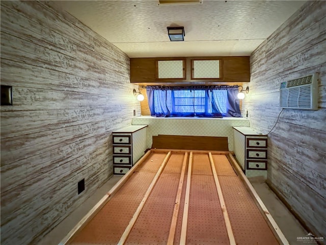 interior space featuring a wall mounted air conditioner and wooden walls