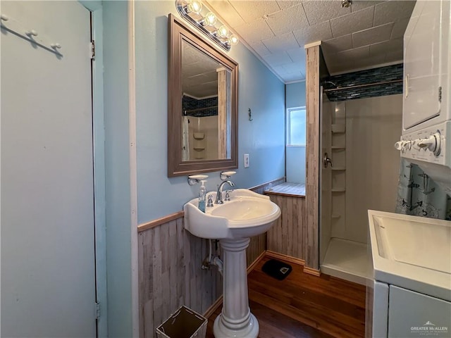 bathroom with walk in shower, wood walls, and hardwood / wood-style flooring