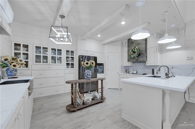 1909 Lake Point Dr, Mission, TX 78572 - kitchen with freestanding refrigerator, white cabinets, backsplash, a sink, and a peninsula