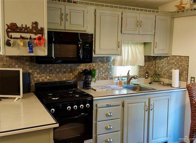 kitchen featuring black appliances, backsplash, white cabinets, and sink