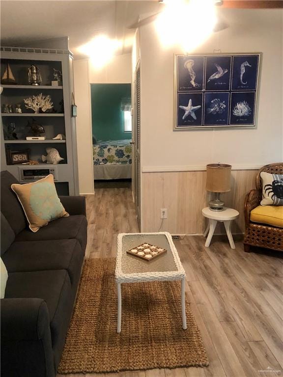 living room with wood-type flooring and wooden walls